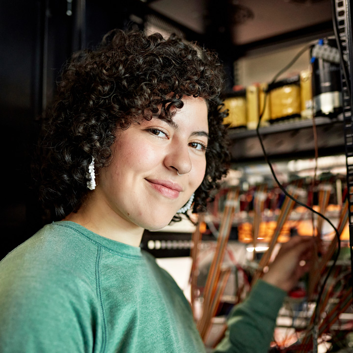 Young person in green shirt working on a server.